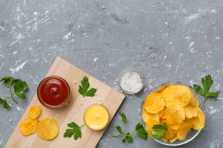Top view chips with sause in bowl on colored background, top view with copy space.の写真素材