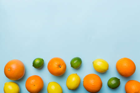 fruit background. Colorful fresh fruits on colored table. Orange, lemon, grapefruit Space for text healthy concept. Flat lay, top view, copy space.の写真素材