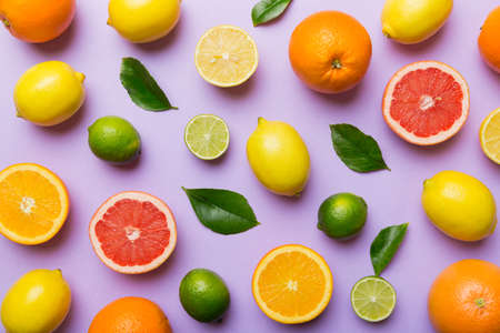 Flat lay of citrus fruits like lime, orange and lemon with lemon tree leaves on light colored background. Space for healthy text concept. top view.の写真素材