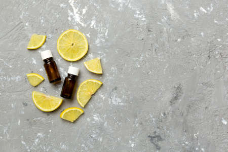 Bottles with lemon fruit essential oil on wooden background. alternative medicine top view with copy...