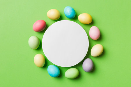 round frame multicolored Easter eggs with white blank paper on a brown background, close-up, space for text, blank for design, selective focus, tinted image.の写真素材