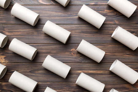 Empty toilet paper roll on colored background. Recyclable paper tube with metal plug end made of kraft paper or cardboard.の写真素材