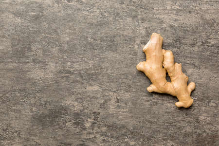 Finely dry Ginger powder in bowl with green leaves isolated on colored background. top view flat...