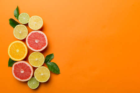 fruit background. Colorful fresh fruits on colored table. Orange, lemon, grapefruit Space for text healthy concept. Flat lay, top view, copy space.の写真素材