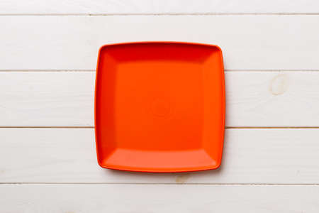 Top view of empty square plate on wooden background. Empty space for your design.の写真素材