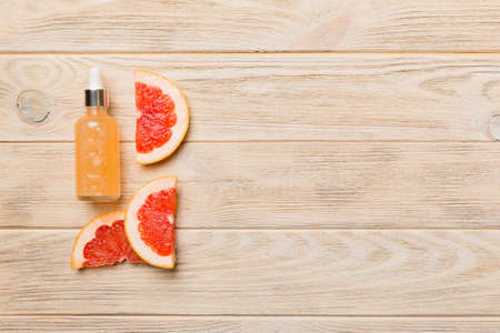 Bottles with orange fruit essential oil on wooden background. alternative medicine top view with copy space.の写真素材