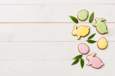 holiday preparation Multi colors Easter eggs with cookies on colored background . Pastel color...