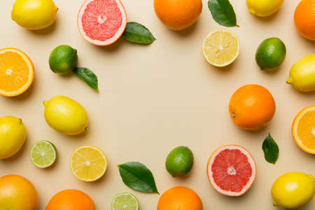 Flat lay of citrus fruits like lime, orange and lemon with lemon tree leaves on light colored background making a frame. Space for healthy text concept.の写真素材
