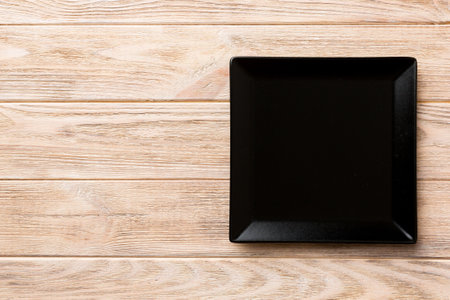Top view of empty square plate on wooden background. Empty space for your design.の写真素材