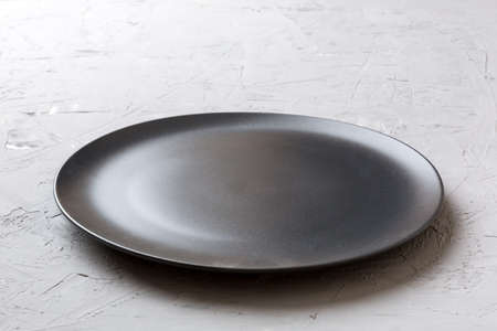 Perspective view of empty black plate on cement background. Empty space for your design.の写真素材