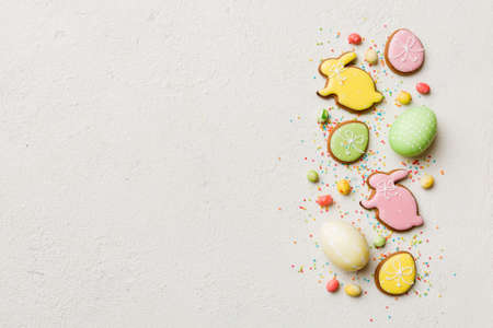 holiday preparation Multi colors Easter eggs with cookies on white background . Pastel color Easter...