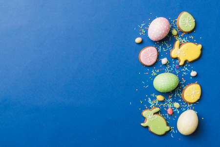 holiday preparation Multi colors Easter eggs with cookies on colored background . Pastel color...