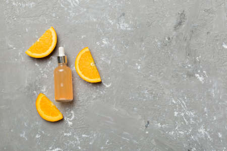 Bottles with orange fruit essential oil on cement background. alternative medicine top view with copy space.の写真素材