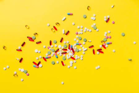 assorted pills and tablets top border over colored background. Many different pills and space for text on colorful background, top view.の写真素材