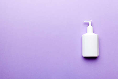 Set of skin care serums on pink pastel background with ostrich feathers. Spa cosmetic product, cream jar, branding mock up, top view with copy space.の写真素材