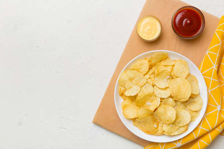 Top view chips with sause in bowl on colored background, top view with copy space.の写真素材