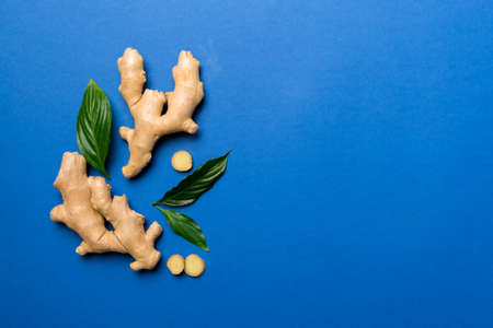 Finely dry Ginger powder in bowl with green leaves isolated on colored background. top view flat lay.の写真素材