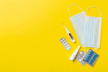 Protective face masks or surgical masks, medicine pills and thermometer on table background....