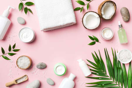 Coconut with jars of coconut oil and cosmetic cream on colored background. top view. Free space for your text. Natural spa coconut cosmetics and organic treatment concept Coconut Spa composition.の写真素材