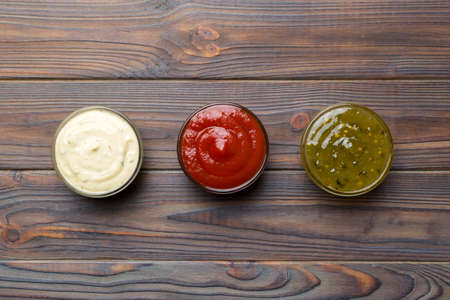 Different types of sauces in bowls on a colored Board . top view. various sauces copy space.の写真素材