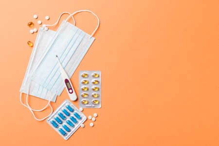 Protective face masks or surgical masks, medicine pills and thermometer on table background....