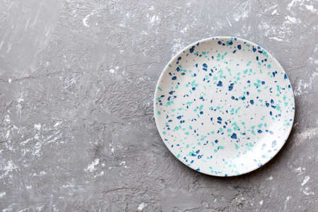 Top view of empty blue plate on cement background. Empty space for your design.