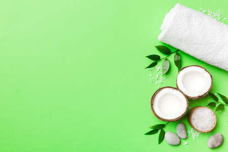 Coconut with jars of coconut oil and cosmetic cream on colored background. top view. Free space for your text. Natural spa coconut cosmetics and organic treatment concept Coconut Spa composition.の写真素材