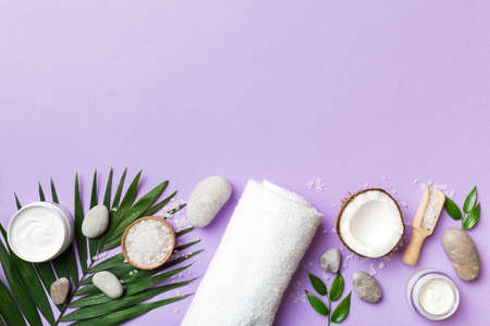 Coconut with jars of coconut oil and cosmetic cream on colored background. top view. Free space for your text. Natural spa coconut cosmetics and organic treatment concept Coconut Spa composition.の写真素材