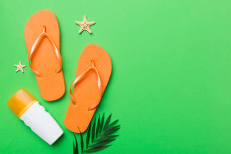 Flat lay composition with flip flops and seashell on colored background. Space for text view.の写真素材