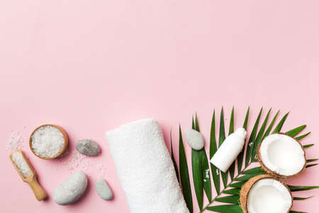 Coconut with jars of coconut oil and cosmetic cream on colored background. top view. Free space for your text. Natural spa coconut cosmetics and organic treatment concept Coconut Spa composition.の写真素材