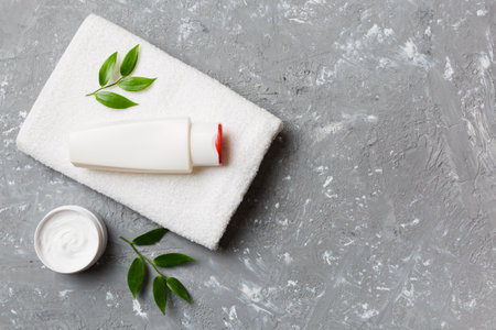 Cosmetic bottle shampoo mockup with towels on a colored table. Bathroom background, toilet accessories for hand and body care.の写真素材