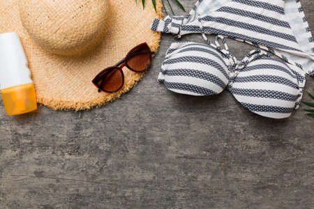 Woman swimwear and beach accessories flat lay top view on colored background Summer travel concept....