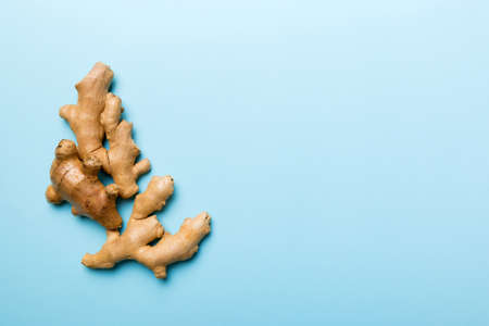 Finely dry Ginger powder in bowl with green leaves isolated on colored background. top view flat...