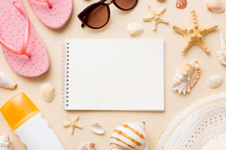 Blank writing book with summer beach accessories on background, copy space. Flat lay with copy...