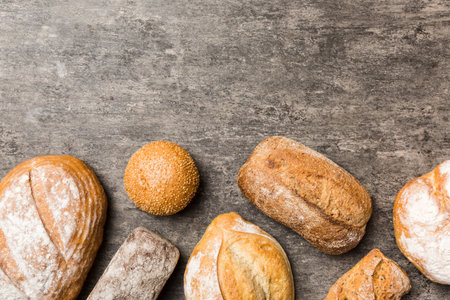Homemade natural breads. Different kinds of fresh bread as background, top view with copy space.