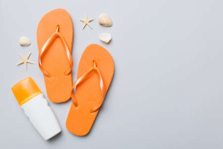 Summer travel concept. beach accessories. Flip flops and starfish on white. Top view on colored...