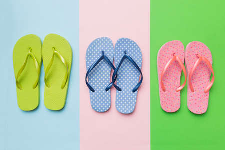 Stylish beach flip-flops on color background, top view.の写真素材