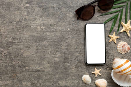 Flat lay composition with Phone and beach accessories on colored background. Smartphone with blank screen mock up with copy space.の写真素材