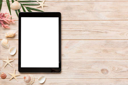 Flat lay composition with tablet and beach accessories on colored background. Tablet computer with blank screen mock up with copy space.の写真素材