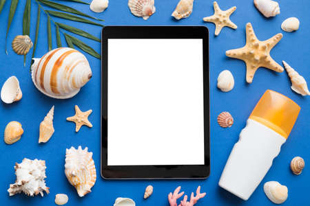 Flat lay composition with tablet and beach accessories on colored background. Tablet computer with...