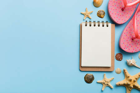 Blank writing book with summer beach accessories on background, copy space. Flat lay with copy space.の写真素材