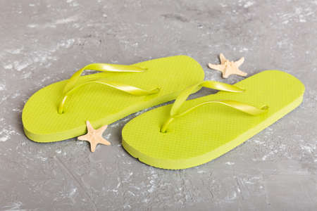 beach accessories. Flip flops and starfish on colored background. Top view Mock up with copy space.の写真素材