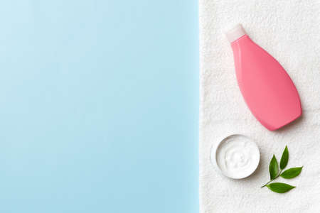 Cosmetic bottle shampoo mockup with towels on a colored table. Bathroom background, toilet accessories for hand and body care.の写真素材