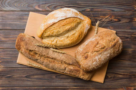 Freshly baked bread on cutting board against white wooden background. top view bread with copy...