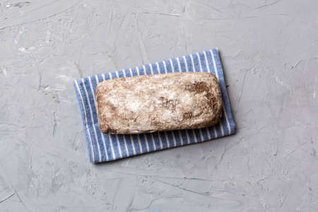 Fresh rye bread on napkin on rustic background, fresh bread top view.