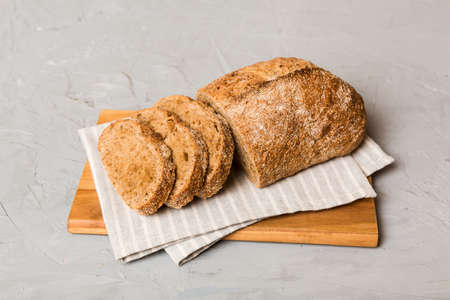 Assortment of freshly sliced baked bread with napkin on rustic table top view. Healthy unleavened...