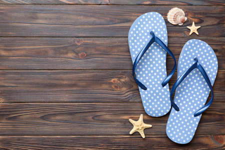 Flat lay composition with flip flops and seashell on colored background. Space for text view.の写真素材