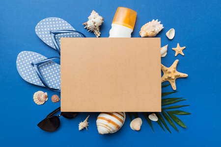 Summer time concept with blank greeting card and blank craft paper on colored background. Seashells...