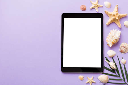 Flat lay composition with tablet and beach accessories on colored background. Tablet computer with...