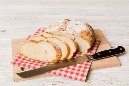 Assortment of freshly sliced baked bread with napkin on rustic table top view. Healthy unleavened...